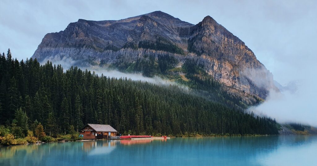 emerald lake with cabin and canoes