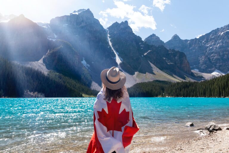 woman wearing canadian flag in front of lake louise