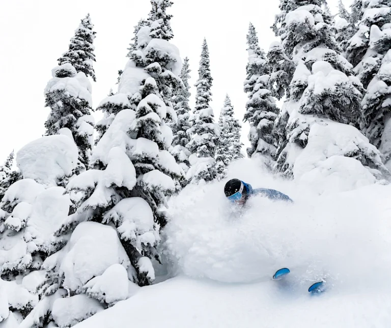 person skiing with face shot of powder