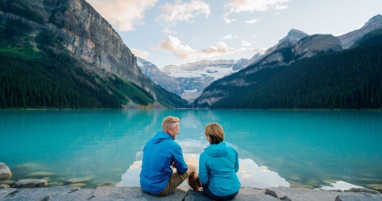 couple sitting in front of lake louise on small group tour