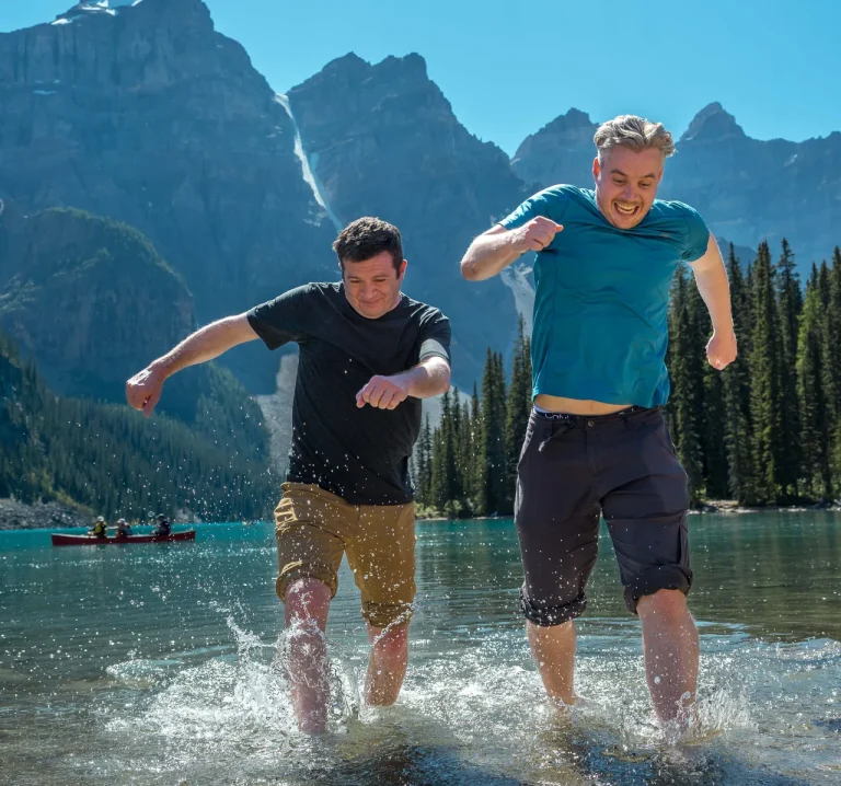 two men running out of the water in Moraine Lake